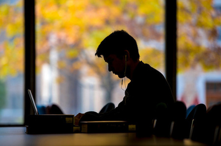Student working in Hesburgh Library in fall.